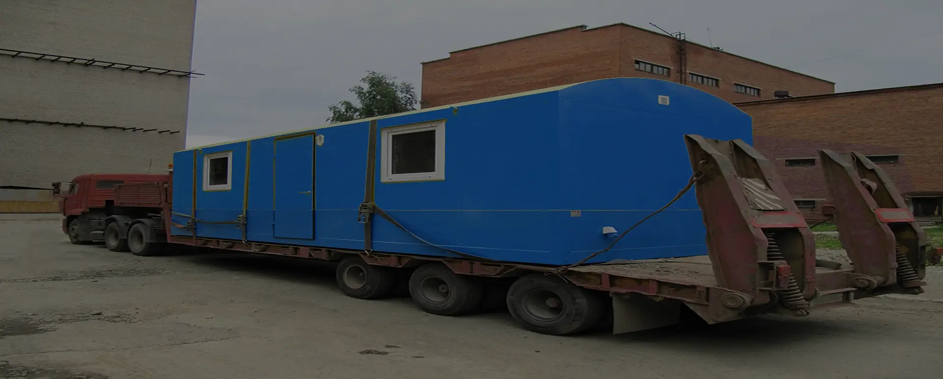 Заказать безопасную и качественную перевозку вагон домов и блок комнат по России из Русской Поляны специализированными низкорамными тралами